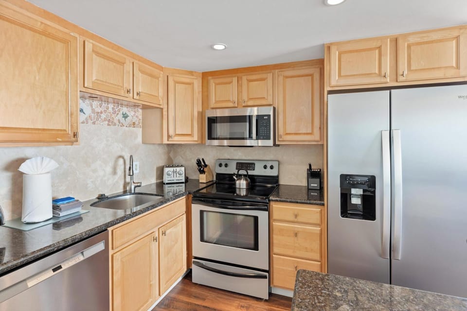 Enjoy a fully equipped kitchen with sleek appliances, perfect for creating family meals during your beachfront getaway.'
