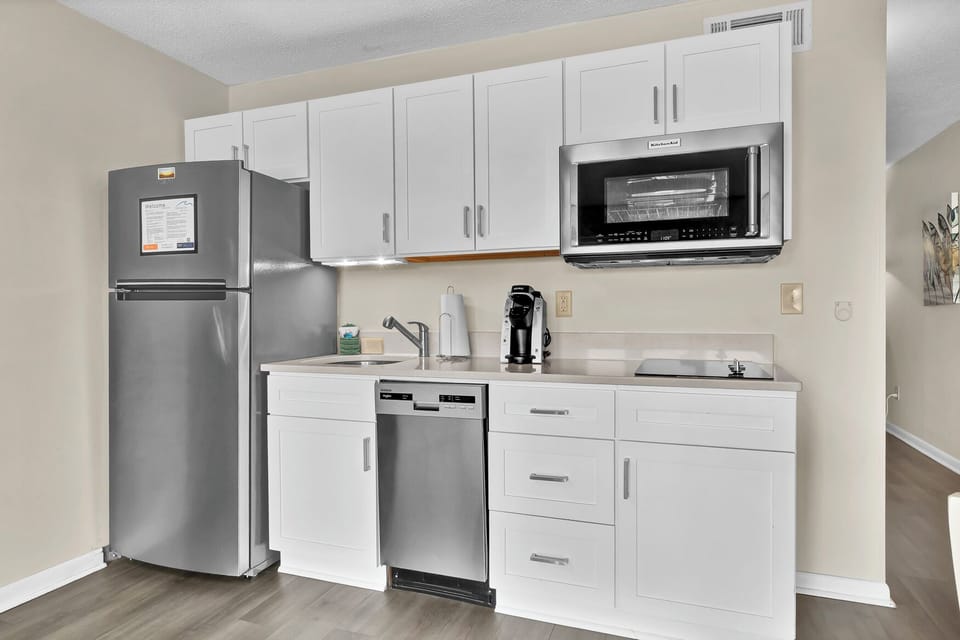 Your modern kitchenette features stainless steel appliances and crisp white cabinets, perfect for preparing meals during your stay.