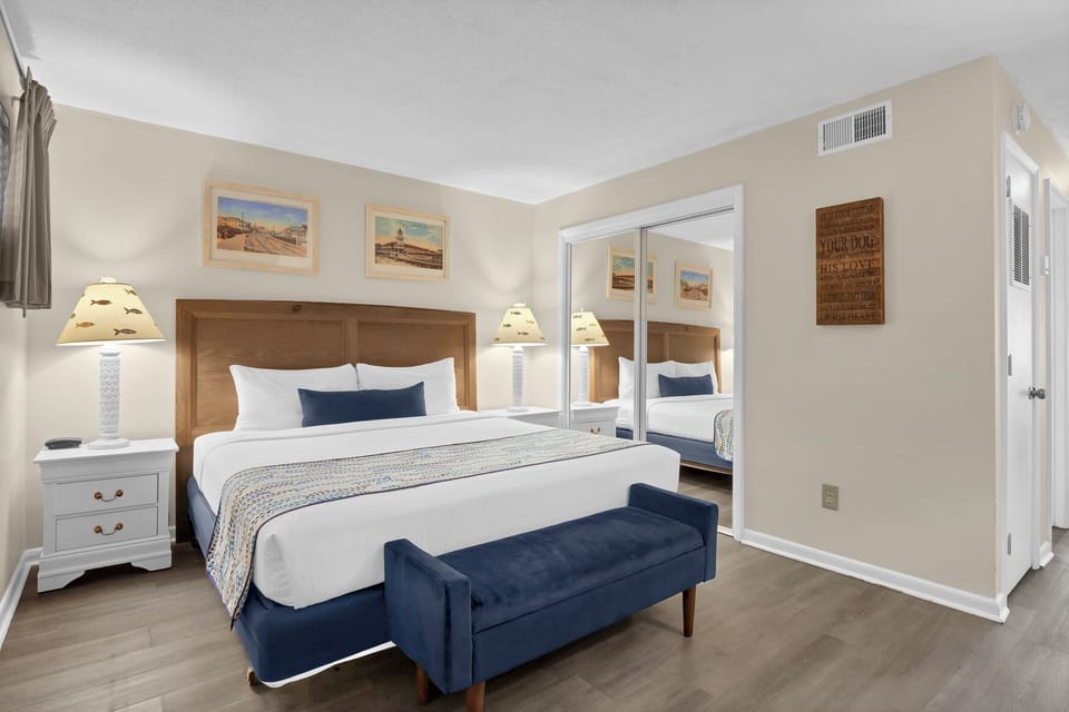 Relax in your comfortable bedroom featuring a plush king bed and coastal-themed decor that creates the perfect beachside retreat.