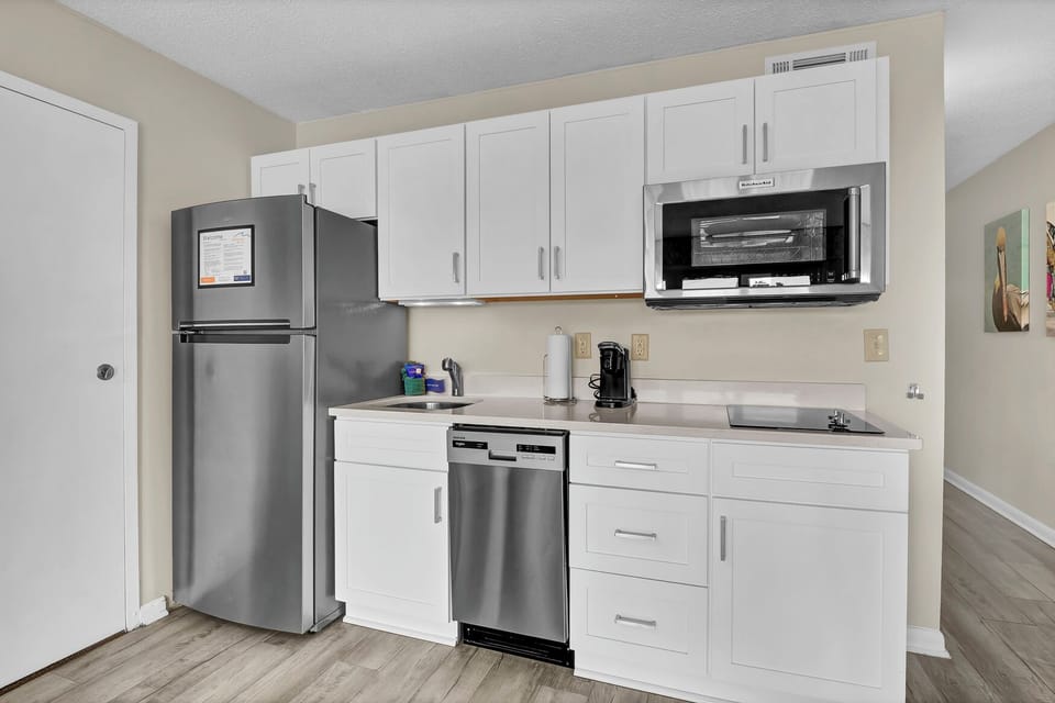 Your fully equipped kitchen features stainless steel appliances and bright white cabinets, perfect for preparing meals during your stay.