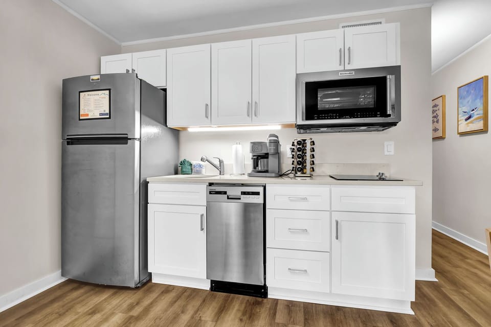 Kitchen, with two burner induction stove top, microwave and convection oven, sink, Keurig, and dishwasher