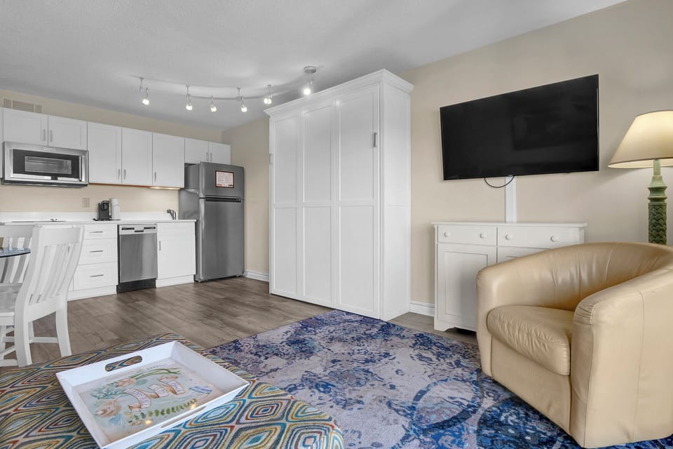 Your stylish studio features a fully equipped kitchen, comfortable seating area with large TV, and smart storage solutions for a perfect stay.