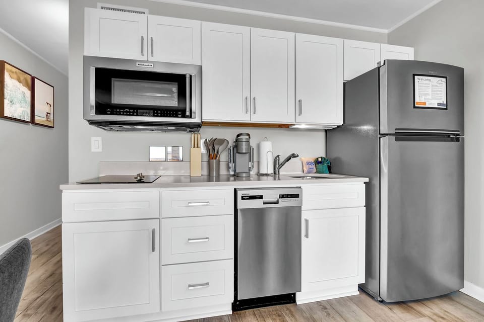 Kitchen, with two burner induction stove top, microwave and convection oven, sink, Keurig, and dishwasher