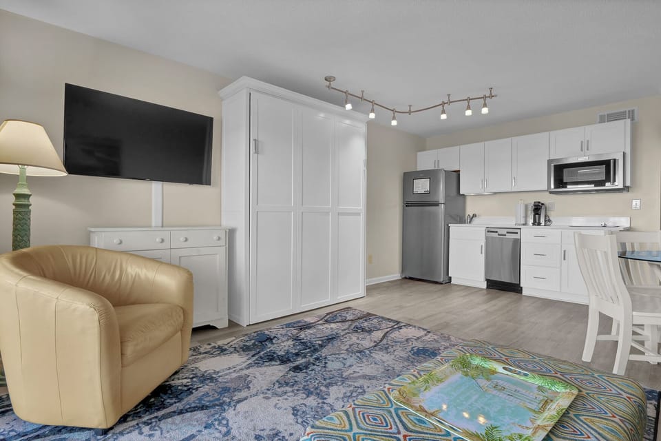 Step into your bright studio where modern comfort meets convenience—a fully equipped kitchen, cozy seating, and smart storage await your arrival.