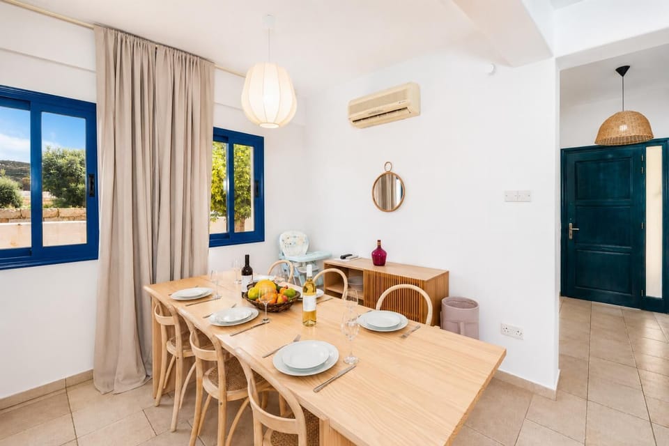 Open-plan living room with sofa, dining area, kitchen, A/C, WiFi internet, and satellite TV