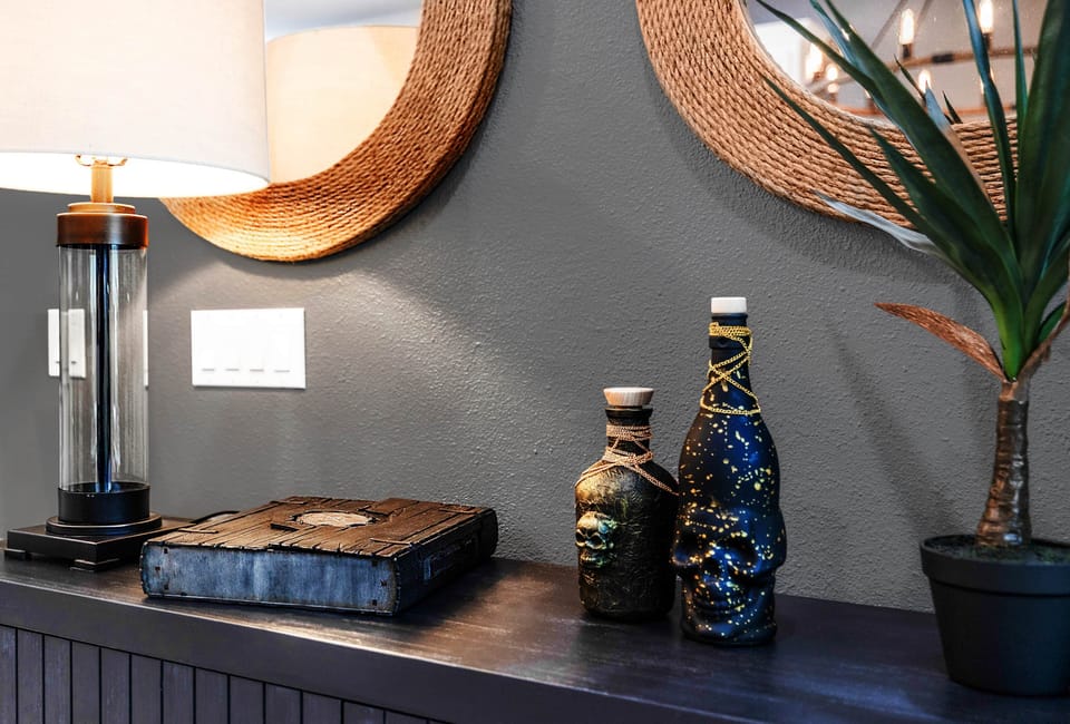 Skull-adorned bottles and a weathered journal evoke pirate lore beneath warm lighting.