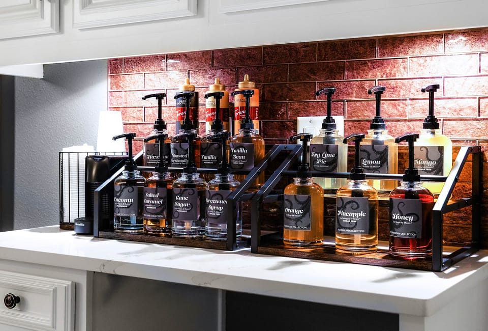 Syrup bar stocked with tropical and dessert flavors for custom coffee and mocktail creations.