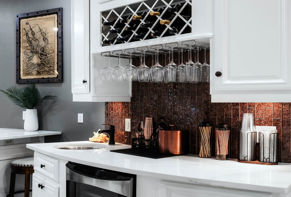 Wet bar with glassware, copper accents, and a built-in wine rack—ready for happy hour.