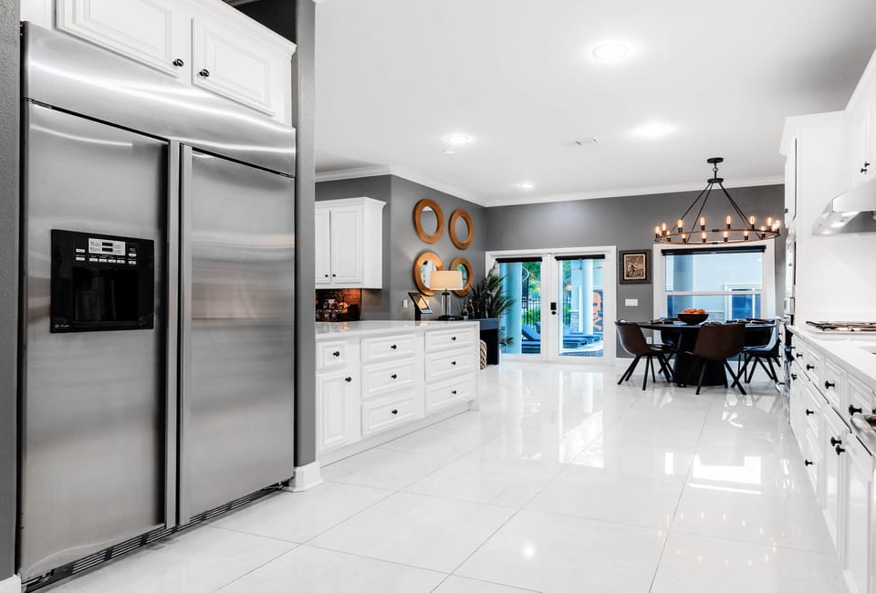 Spacious stainless steel fridge anchors this bright kitchen, with pool views just steps away.