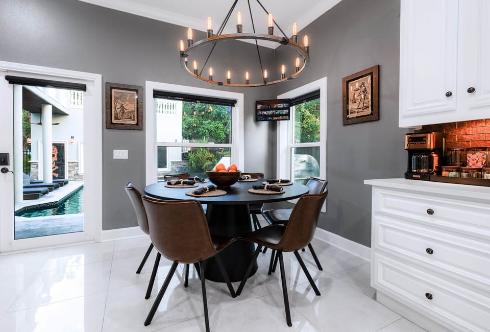 Cozy kitchen nook with pool views, pirate art, and a coffee bar tucked beneath warm amber lighting. 