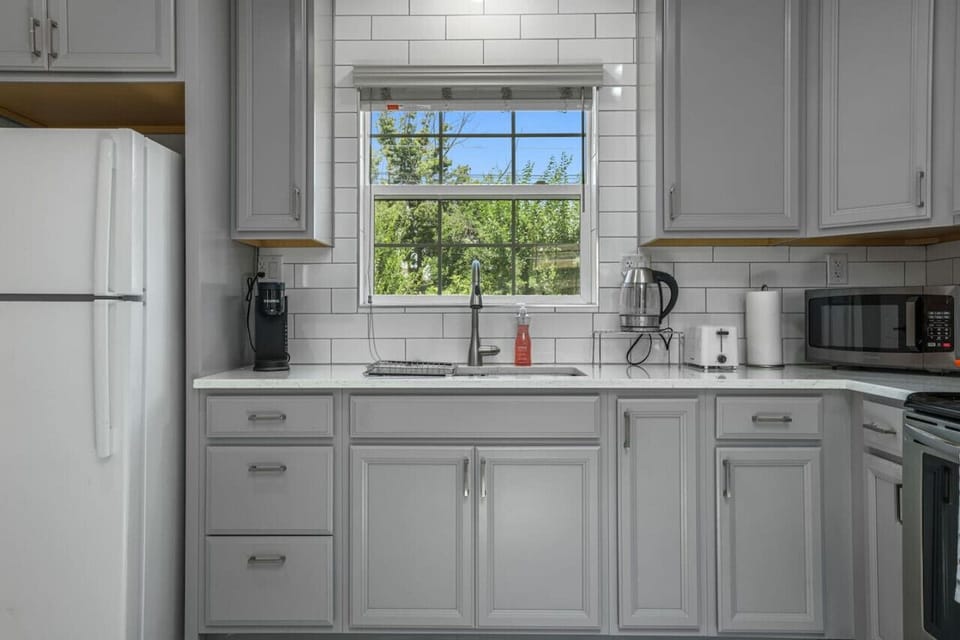 **Bright and Modern Kitchen**  Our bright and modern kitchen is fully equipped for all your culinary needs. With sleek appliances and a large window offering natural light, it’s perfect for preparing meals and enjoying your stay. Book now to experience co