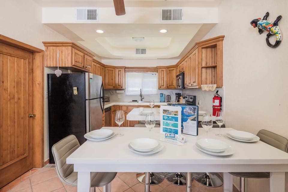 Fully equipped kitchen with stainless steel appliances and a dining area set for six perfect for enjoying home-cooked meals together.