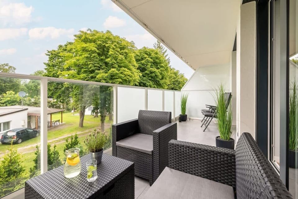 The furnished balcony with comfortable chairs and a table invites guests to enjoy outdoor moments.