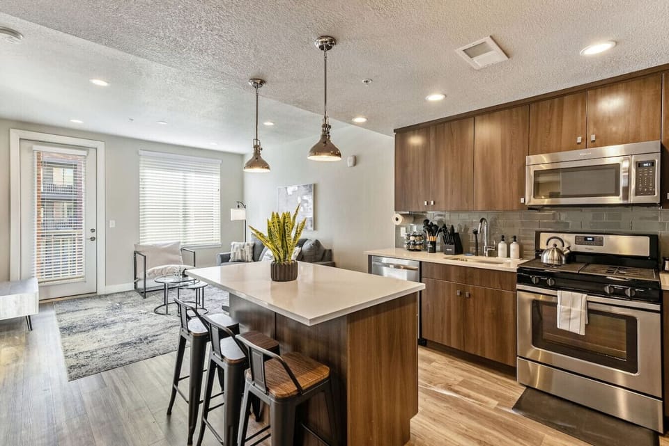 Modern kitchen w/ island seating, stainless appliances & warm wood cabinetry