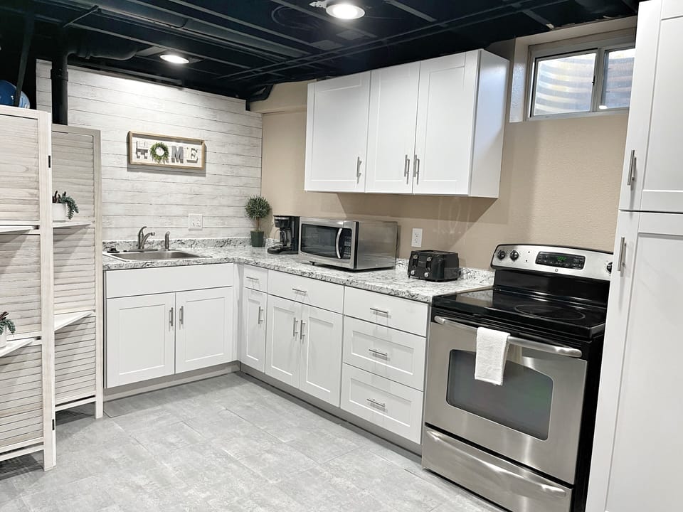 Kitchen includes a full range, microwave, toaster, coffee maker and fridge