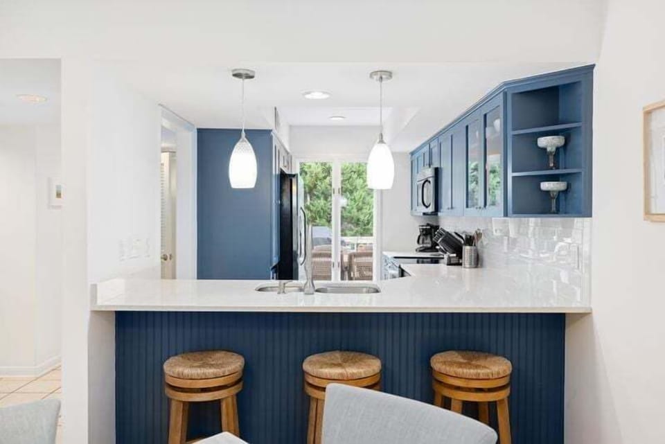Bar stools sit at the counter between the dining area and the kitchen