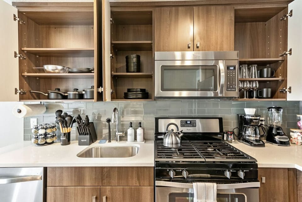 Well-equipped kitchen w/ open shelving, stainless range & everything within reach