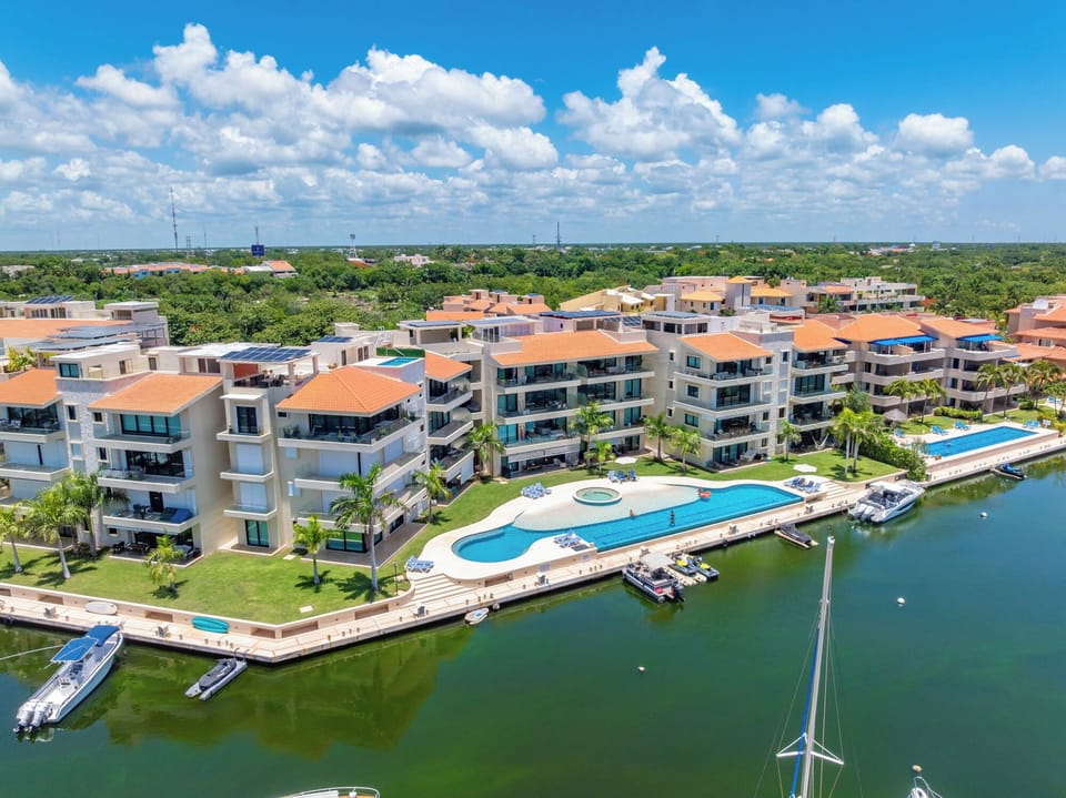 Vista aérea del condominio con piscina infinita y marina privada