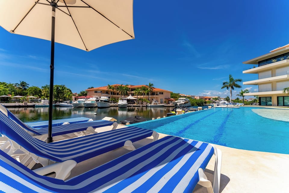 Piscina infinita frente a la marina con camastros y vistas espectaculares