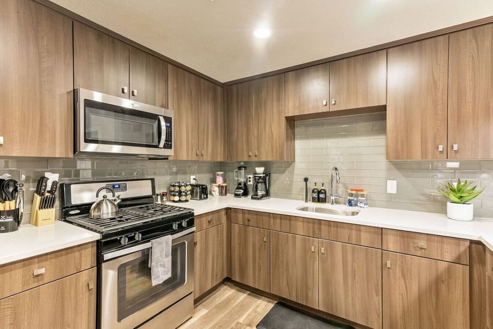Modern kitchen w/ wood cabinetry, stainless appliances & plenty of counter space