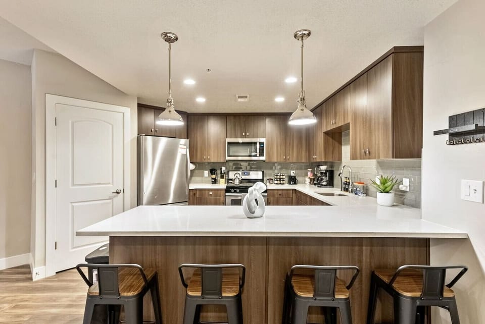 Modern kitchen w/ spacious island seating, sleek counters & stainless appliances for easy meals