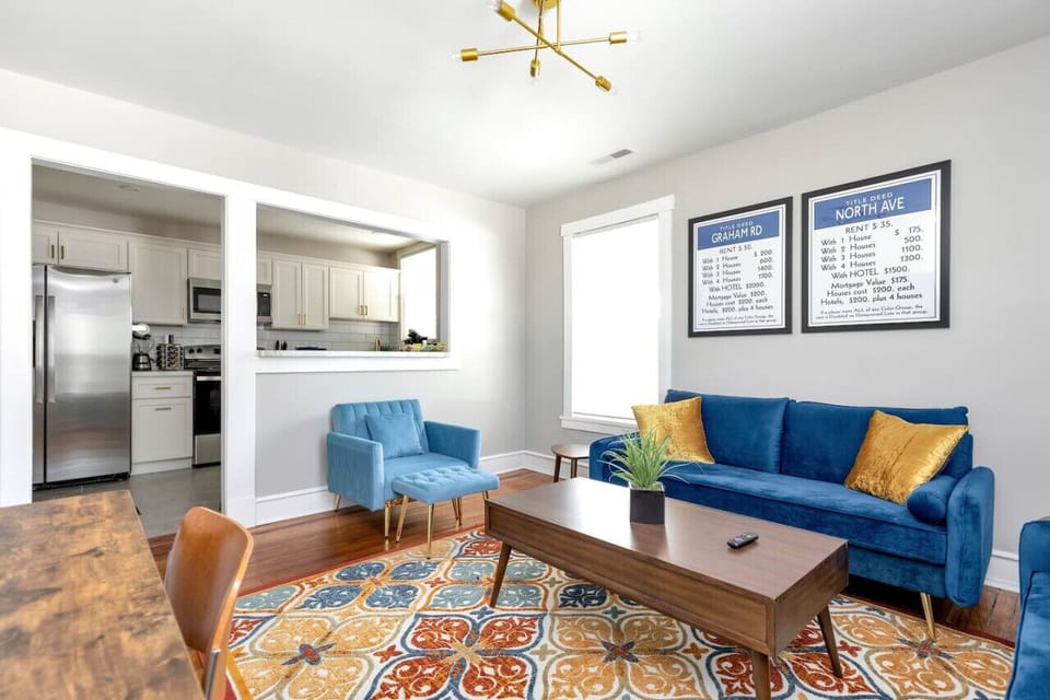 “Free Parking”  Kick back in the Monopoly-inspired living room with two plush couches, a lounge chair with ottoman, and a dedicated workspace. Bright pops of modern décor set the scene, while the Roku TV keeps entertainment just a click away.