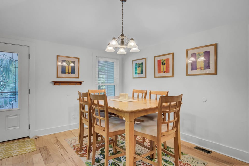 - Gather for meals, game night, or morning coffee in this sunlit dining space - Charming light fixture and colorful framed art add warmth and personality - Whether casual or special, every meal feels joyful around this inviting table