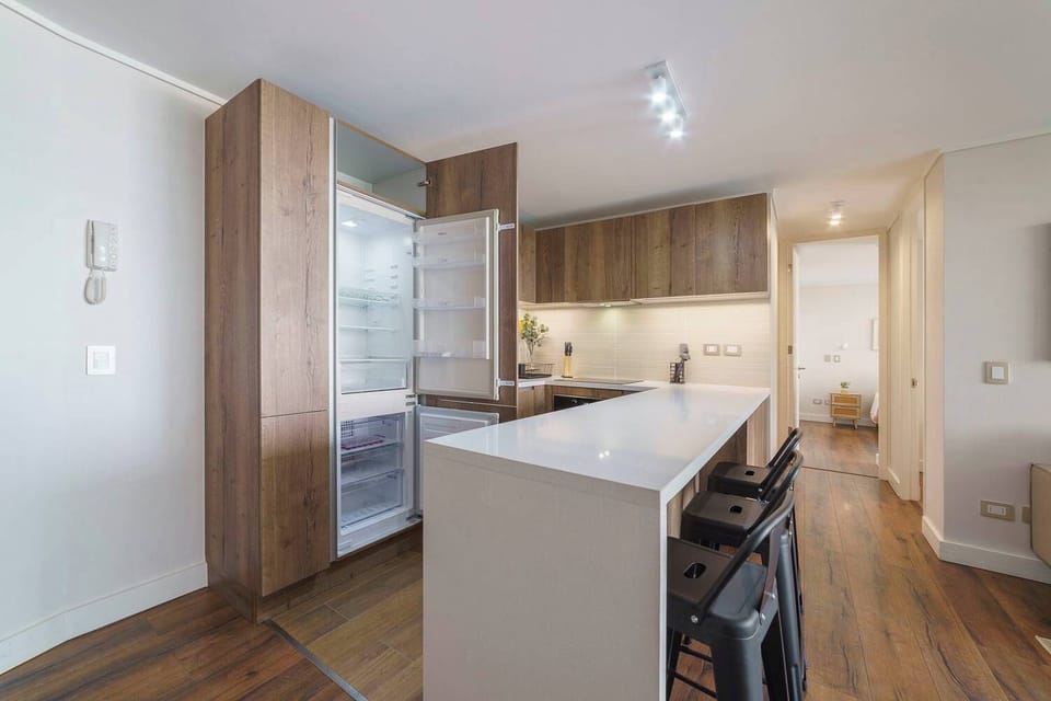Sleek and modern kitchen with ample counter space and stylish bar seating, perfect for cooking and dining.