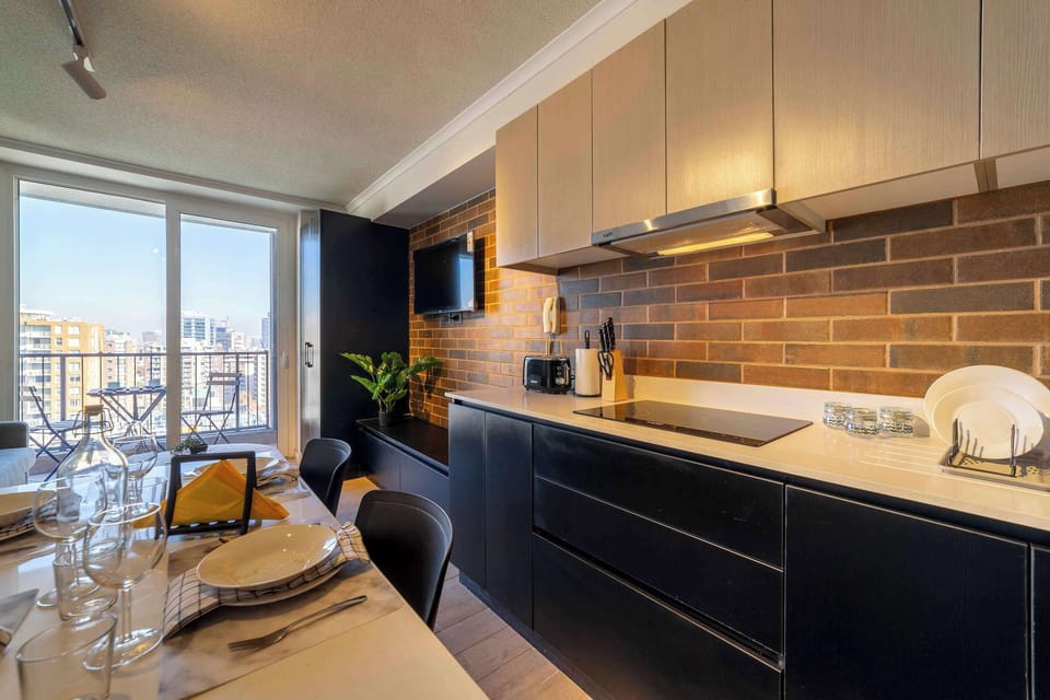 Sleek kitchen with city views, perfect for intimate dining and enjoying the skyline from your private balcony.