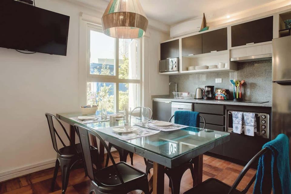 Bright and modern kitchen with a glass-top dining table, perfect for enjoying meals with a view.
