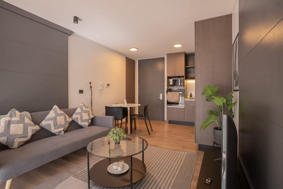 Cozy modern living space with sleek design, perfect for relaxing or entertaining, complete with a stylish kitchen and dining area.