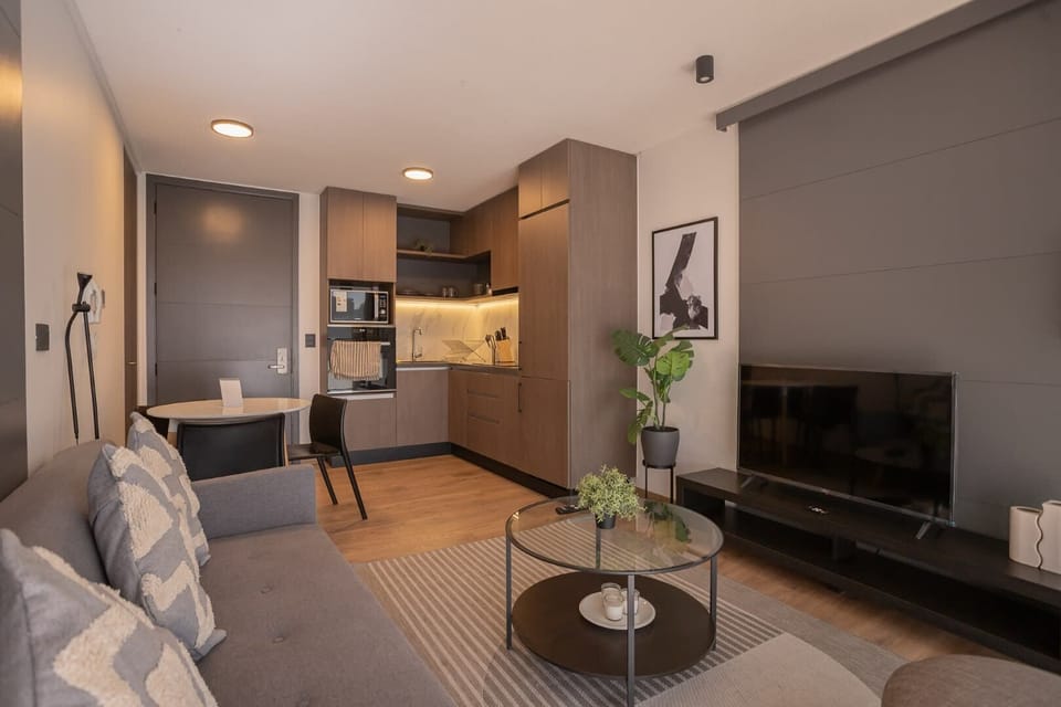 Cozy modern living space with a sleek kitchen, perfect for relaxing or entertaining.