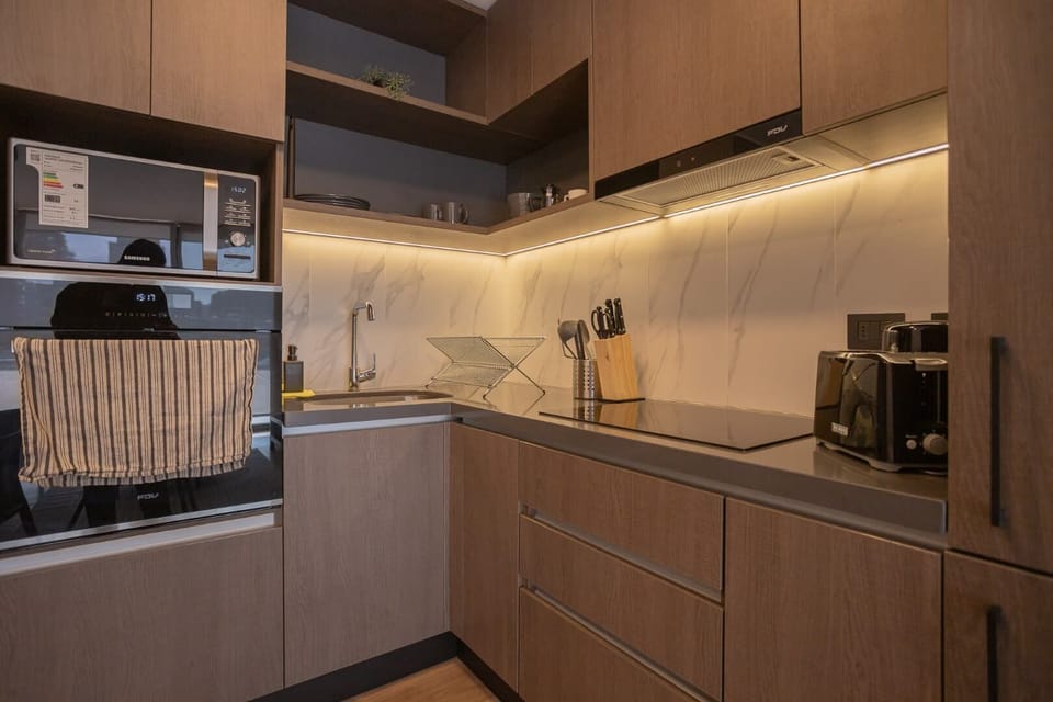 Modern kitchen with sleek appliances and elegant lighting, perfect for culinary adventures.