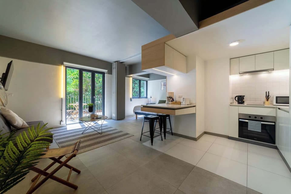 Enjoy cooking in a modern, compact kitchen with natural light and a view of lush greenery from the balcony.