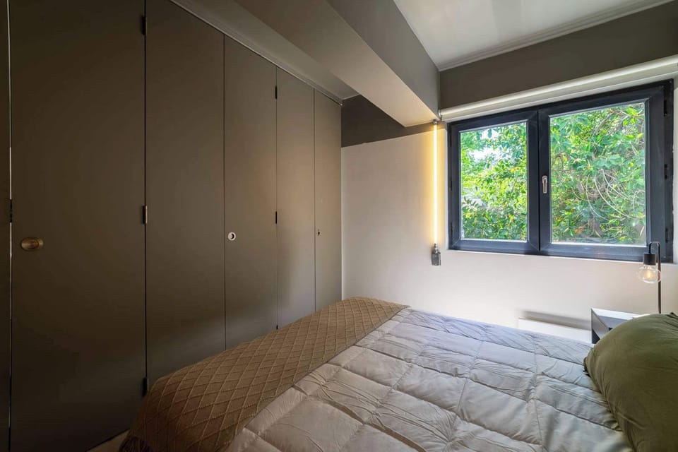 Relax in this serene bedroom with a lush garden view, perfect for a restful night's sleep.