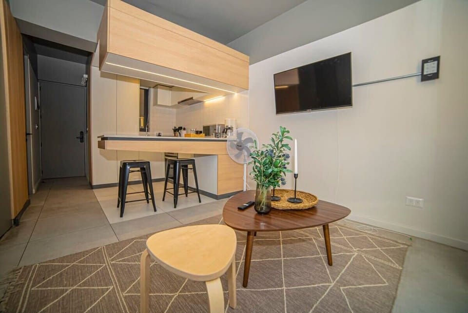 Cozy studio living area with modern kitchen and stylish decor, perfect for a relaxing stay.