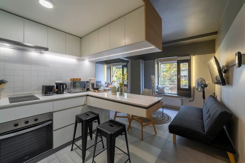 Stylish and fully equipped kitchen with modern appliances and cozy seating area, perfect for relaxing after a day of exploring Santiago.