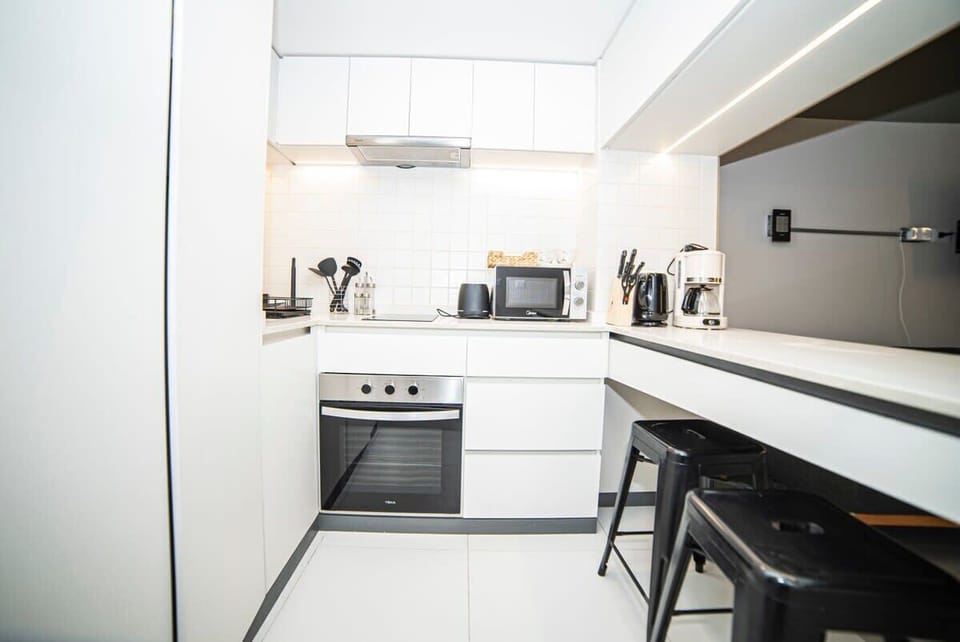 Sleek and modern kitchen with all essentials, perfect for cooking and enjoying meals at the stylish bar seating.