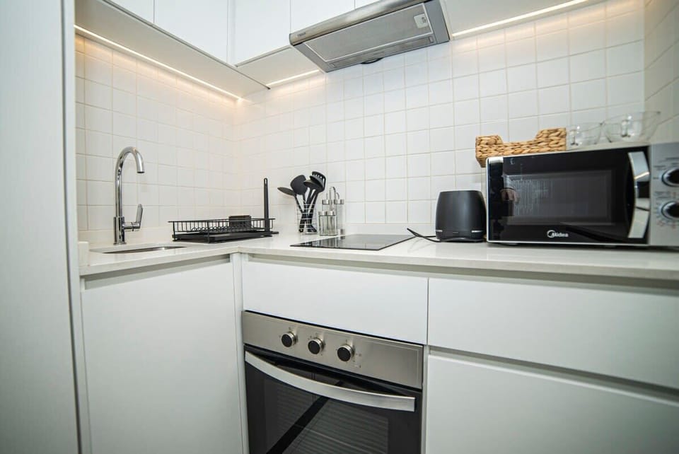Modern compact kitchen with sleek appliances and ample lighting, perfect for preparing your favorite meals.