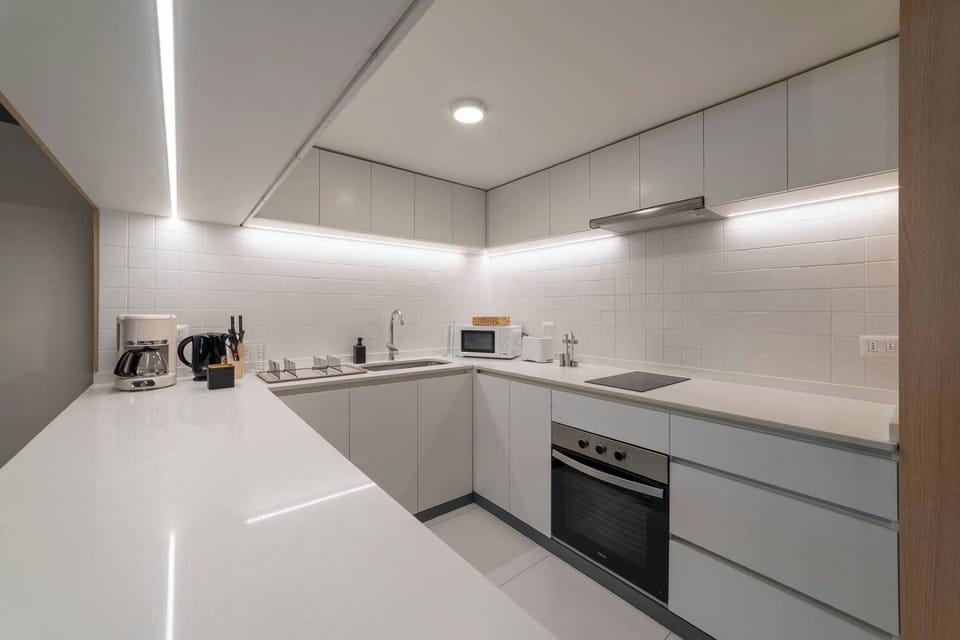 Experience culinary delight in this sleek, modern kitchen equipped with top-notch appliances and ample space for your cooking adventures.