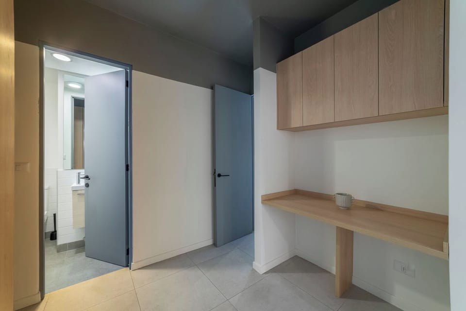 Sleek workspace with easy bathroom access, ideal for productivity in a modern studio.