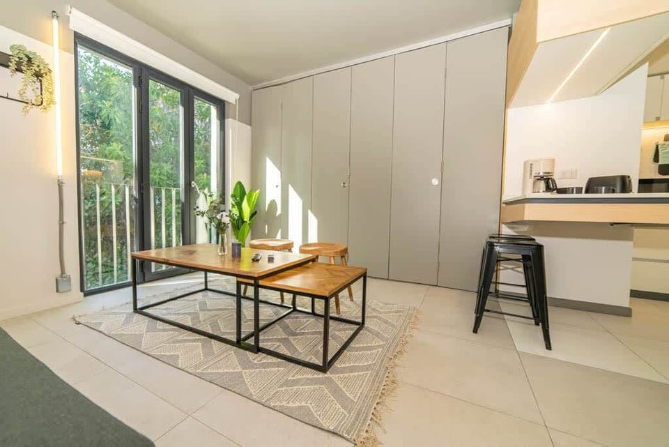 Bright and airy living space with modern decor and a view of lush greenery, perfect for relaxation.