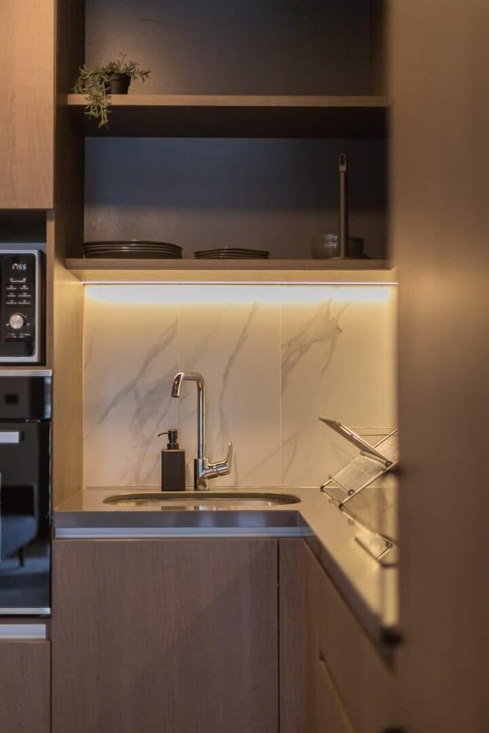 Modern and efficient kitchen with sleek design and ambient lighting, perfect for a cozy meal in your Chilean studio retreat.