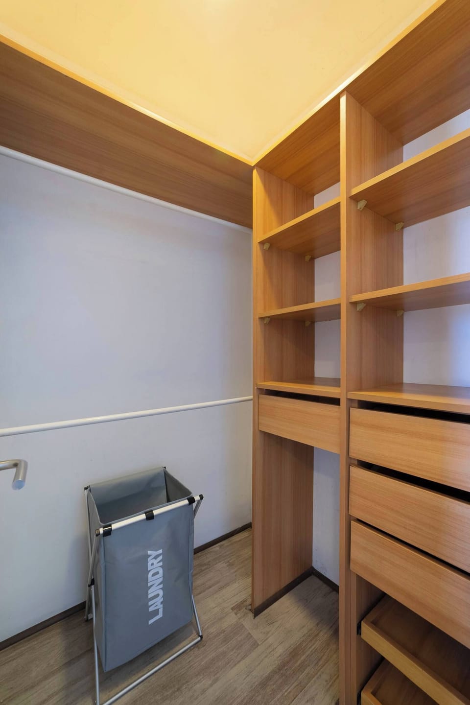 Convenient closet space with ample shelving and a laundry basket for easy organization.