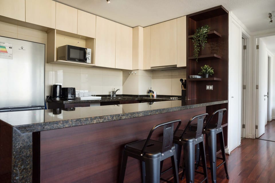 Sleek and modern kitchen with granite countertops and bar seating, perfect for casual dining and entertaining.