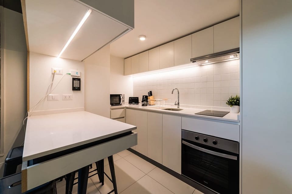 Experience culinary delight in this sleek, fully-equipped kitchen with modern appliances and ample counter space.