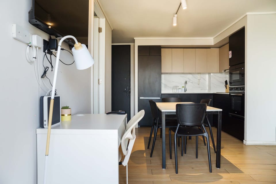 Modern kitchen and dining area with sleek cabinetry and workspace, perfect for a cozy stay.