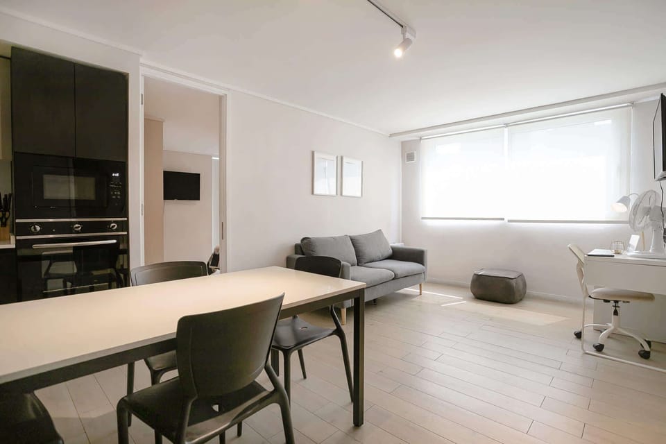 Bright and modern living space with a cozy sofa and workspace, perfect for relaxation and productivity.