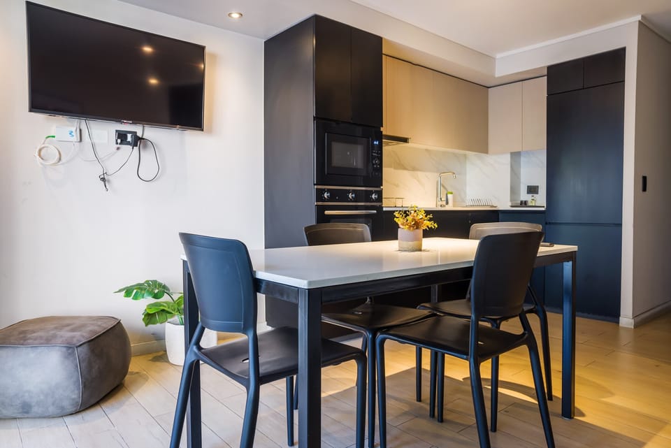 Modern kitchen with sleek design and cozy dining area, perfect for intimate meals in a stylish setting.