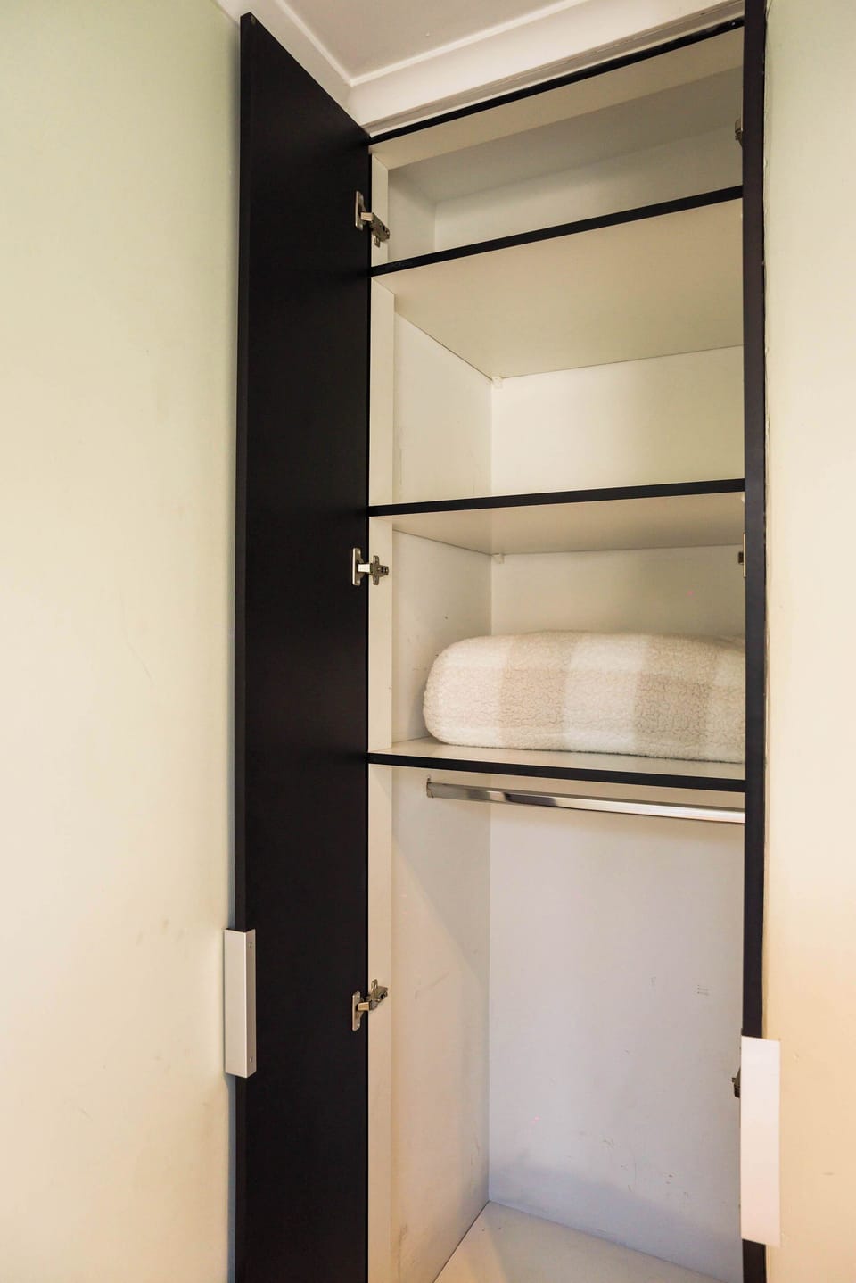 Spacious closet with ample shelving and hanging space, perfect for organizing your belongings during your stay.
